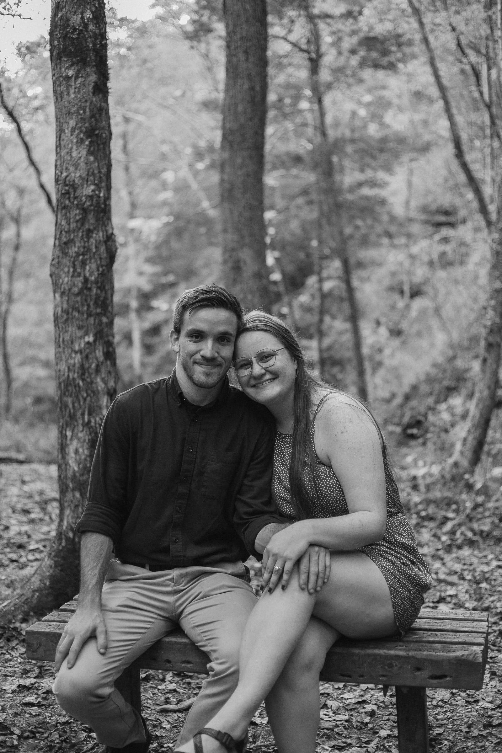 Couple sitting together on bench in forest