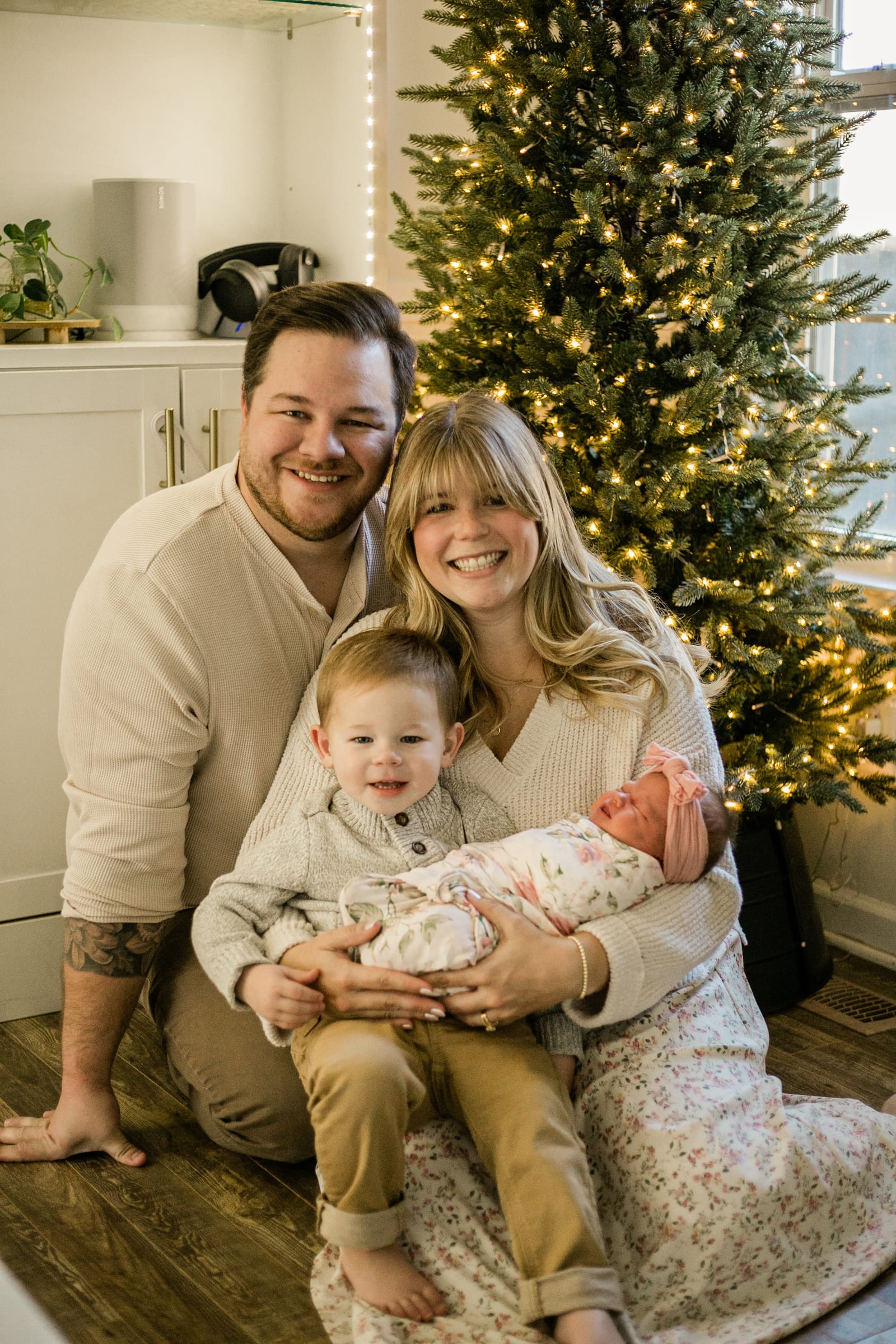 Family with newborn and toddler by Christmas tree
