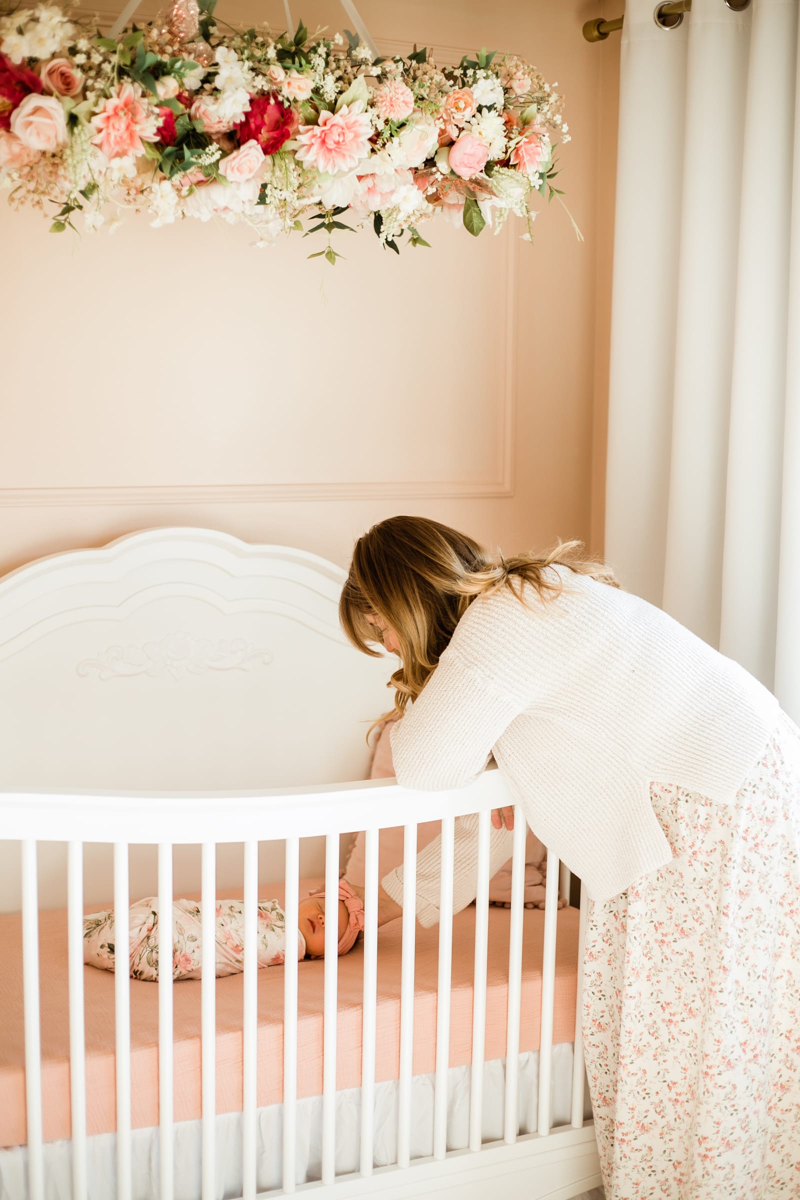 Mother looking into crib at baby