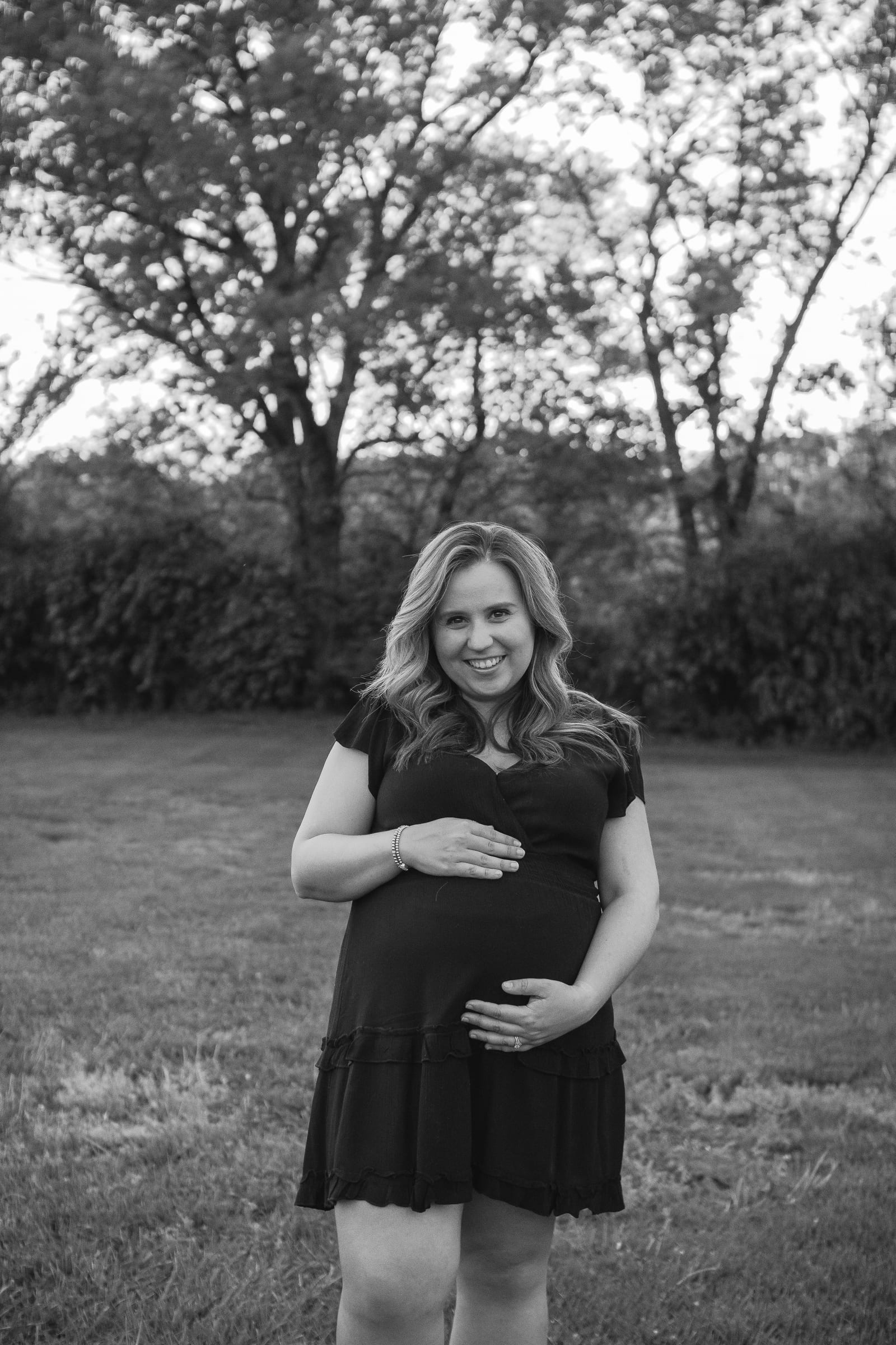Black and white maternity portrait cradling the baby bump